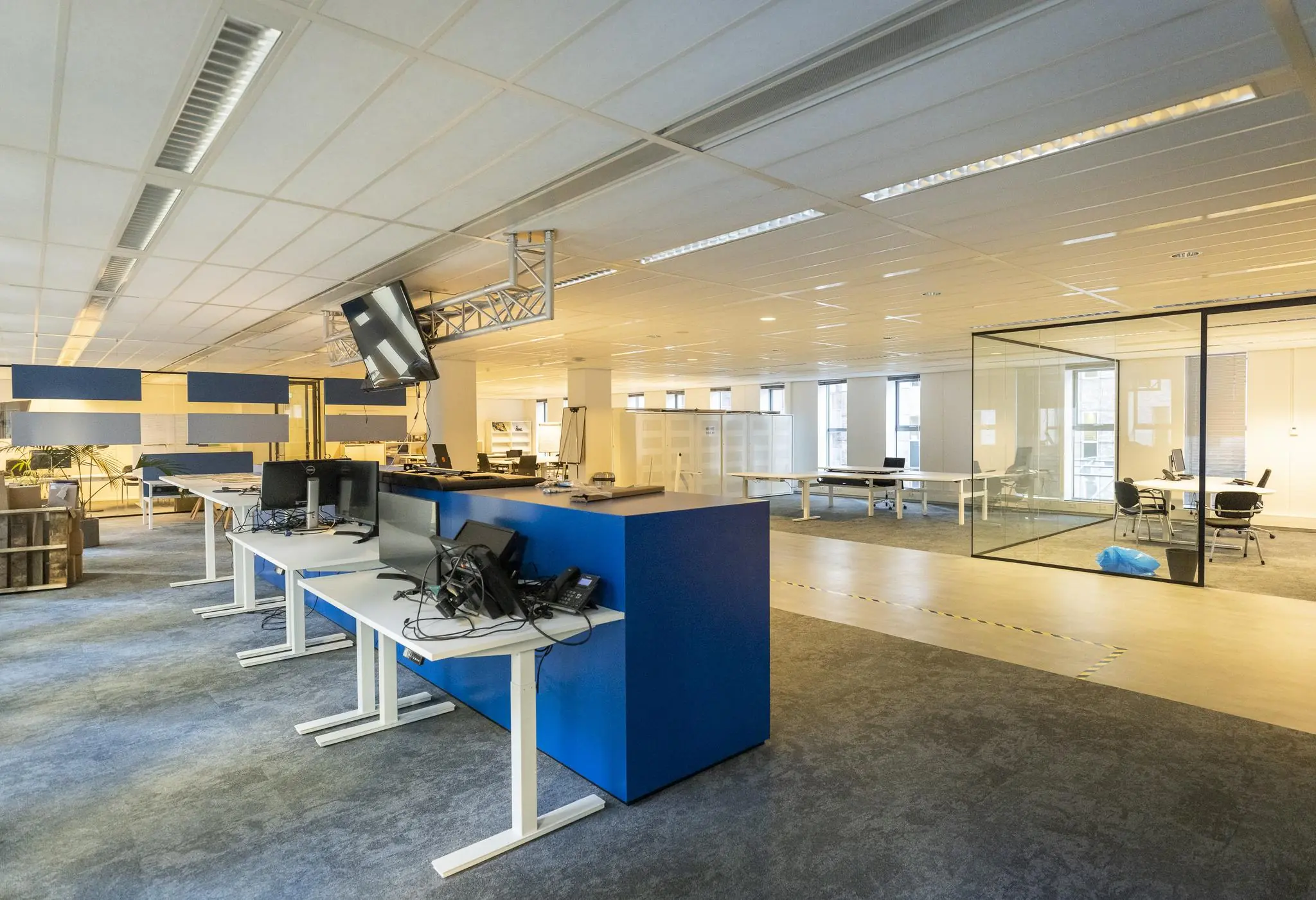 Moderne, open kantoorruimte aan de Prinses Beatrixlaan met werkplekken, glazen vergaderruimte en blauwe accenten.